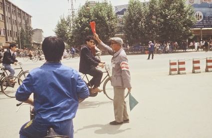 Photo of man directing traffic with red and green flags