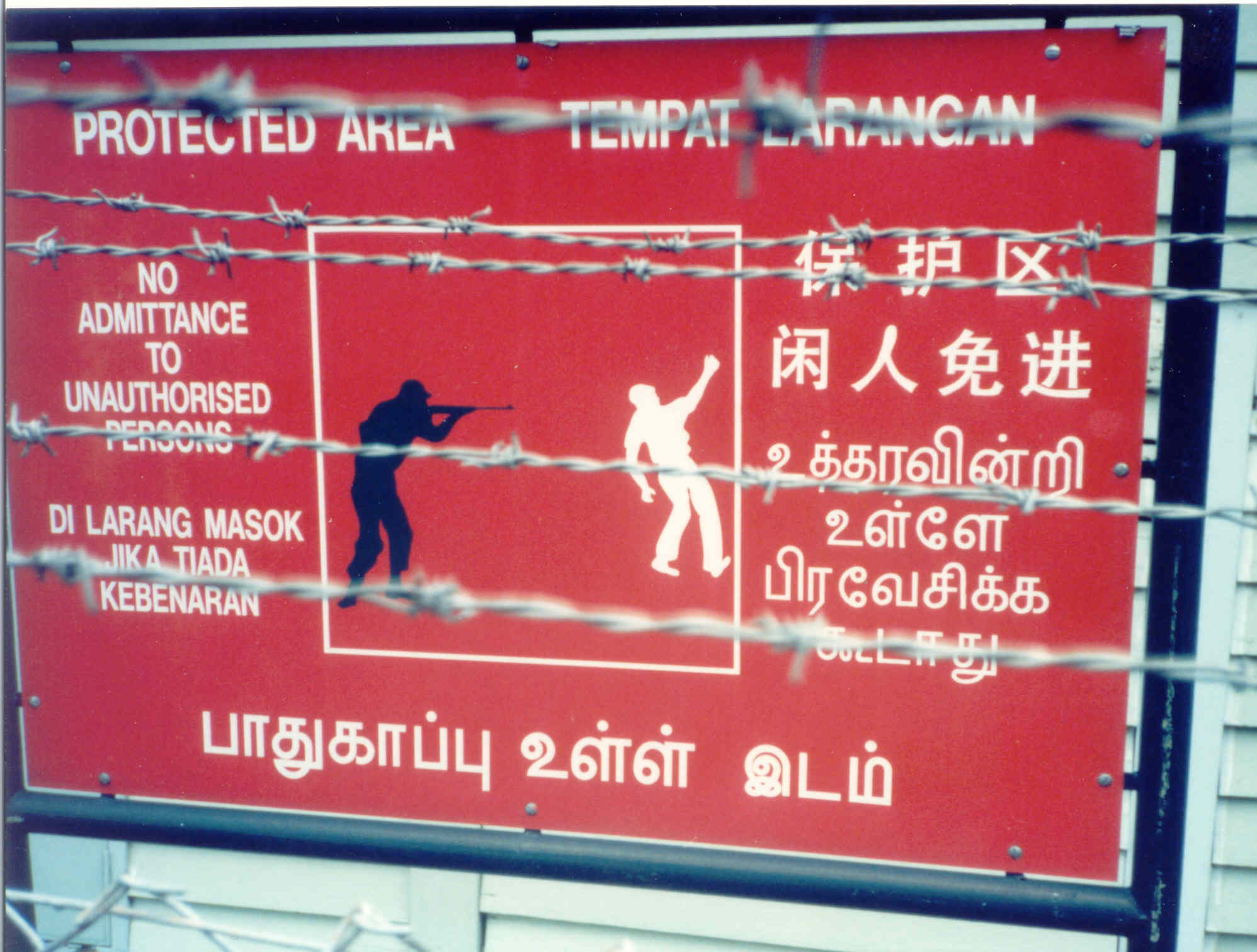 Warning sign with a cartoon figure of a man getting shot